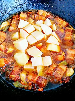 锅中汤汁低于肉时放入土豆、盐，再炖十五分钟左右