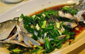 将草鱼盘子取出，把蒸煮过程中产生的水倒掉，加入葱姜丝，贴边倒上蒸鱼豆豉，而后继续蒸5分钟