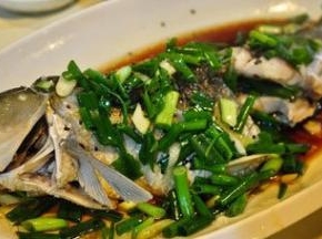 将草鱼盘子取出，把蒸煮过程中产生的水倒掉，加入葱姜丝，贴边倒上蒸鱼豆豉，而后继续蒸5分钟