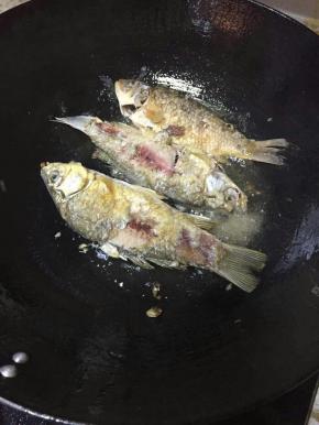 热锅倒油，油开后转小火，将处理好的鲫鱼慢慢滑入锅中煎炸，炸至表皮金黄即可