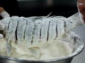 将淀粉和面粉调成糊，在腌好的鲤鱼表面均匀的抹上面糊