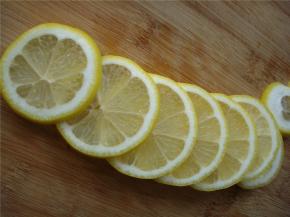 擦干柠檬表面的水分，将柠檬两头去蒂，切成片，同时去除果肉里的柠檬籽