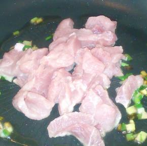 炒锅热油，倒入腌制好的里脊肉片，迅速划炒后盛起。