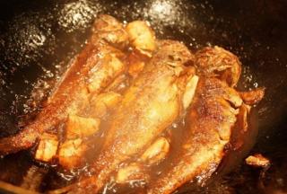 锅中留少许的油，姜蒜片入锅煸炒出香，把炸好的黄鱼倒入锅中，加半碗开水，放入酱油、白糖、盐和料酒，加盖焖煮1-2分钟，撒上鸡精和葱花出锅