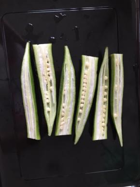秋葵洗净从中间切开，头尾错开摆在烤盘上，鸡胸肉放上面才稳固