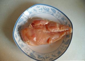 鸡胸肉用水洗净，将表面的白膜撕去，去除油脂