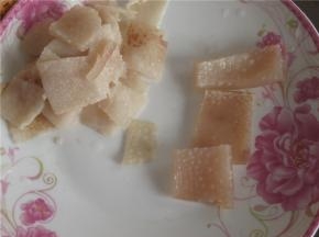将猪皮捞出，冷却后将猪皮上的油脂和毛刮干净。