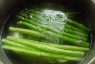 锅内放水，加少许的盐和油，水烧开之后放入芦笋煮2分钟就可以捞出