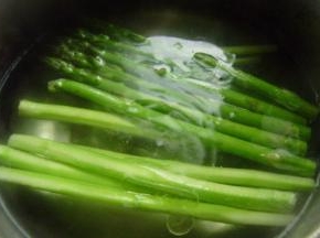 锅内放水，加少许的盐和油，水烧开之后放入芦笋煮2分钟就可以捞出