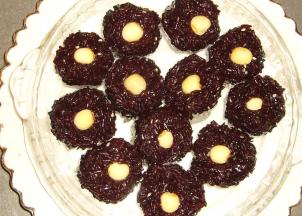 用锡箔纸做成小碗盛具，把搅拌好的黑米放入锡箔纸碗中，上面放上一颗莲子，放入锅中蒸5分钟即可