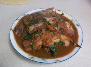 焖好的鱼肉收汁，撒上葱段和香菜出锅