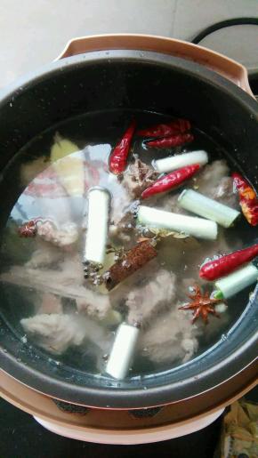 羊肉放入压力锅内，倒入葱姜和香料，加水