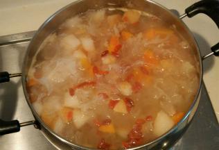 锅中放入大量清水，先将银耳煮20分钟至软烂粘稠，再加入木瓜雪梨煮10分钟，加入冰糖枸杞继续煮10分钟