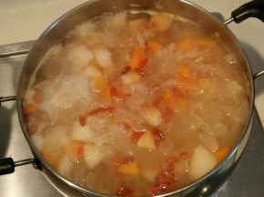 锅中放入大量清水，先将银耳煮20分钟至软烂粘稠，再加入木瓜雪梨煮10分钟，加入冰糖枸杞继续煮10分钟