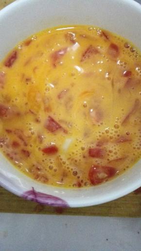 蛋液中倒入切好的番茄丁，加入少许的盐，搅拌均匀
