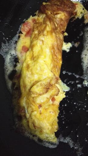 蛋液逐渐凝固之后，从一端卷起，卷成卷
