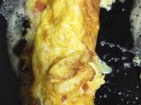 蛋液逐渐凝固之后，从一端卷起，卷成卷
