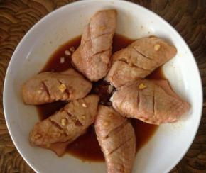 洗净后的鸡翅放入腌制盆中，倒入适量料酒、姜丝、盐、生抽，搅拌均匀后静置30分钟进行腌制入味