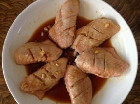 洗净后的鸡翅放入腌制盆中，倒入适量料酒、姜丝、盐、生抽，搅拌均匀后静置30分钟进行腌制入味