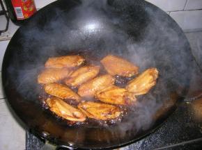 油锅烧热后倒入腌制好的鸡翅，将鸡翅翻炒至金黄色，倒入关键材料——可乐，没过鸡翅为宜