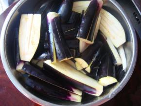 茄子洗净后切成一段段的条状，置碗内用清水浸泡，烹制前再捞出来，这样可以防治茄子变黑。
