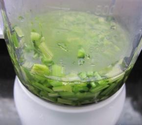  先把芹菜放进榨汁机，按下启动键开始榨汁。