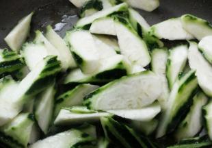 在锅内放入适量植物油，烧热之后放入切好的丝瓜，清炒片刻后倒入适量水；