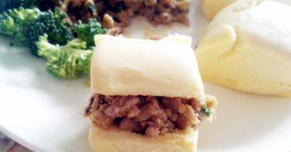 然后把肉馅放入已经热好的油锅中翻炒后装盘。将已经蒸熟的小兔子馒头取出，用剪刀在后侧剪出一个弧度，用来装炒好的肉末。