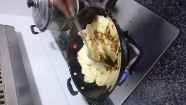 放入土豆片，炒至2-3分钟后倒入事先炒好的猪肉片，加入适量盐，混合翻炒入味