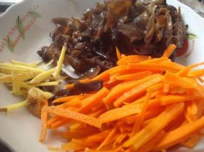 大火热锅加500ml水，将胡萝卜丝和黑木耳下水焯2分钟，沥干备用