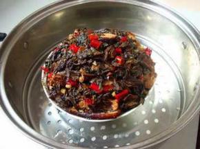 在炸好的五花肉上铺上炒好的梅干菜，上锅蒸2小时
