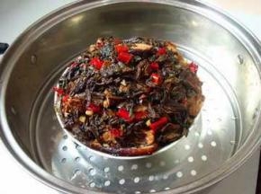 在炸好的五花肉上铺上炒好的梅干菜，上锅蒸2小时