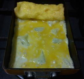 在煎锅的空白部分涂少许的食用油，倒入少许的蛋液，小火慢煎，气泡用筷子戳破