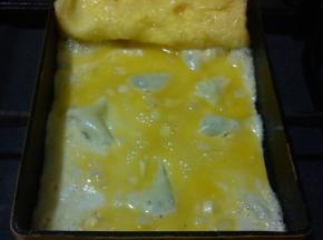 在煎锅的空白部分涂少许的食用油，倒入少许的蛋液，小火慢煎，气泡用筷子戳破