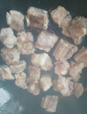 捞出排骨，沥干，炒锅中加入少许油加热，放入排骨，煎至双面金黄