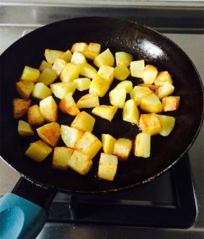 炒锅放油加热，放入土豆块，煎至表皮金黄