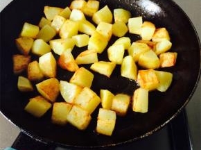 炒锅放油加热，放入土豆块，煎至表皮金黄