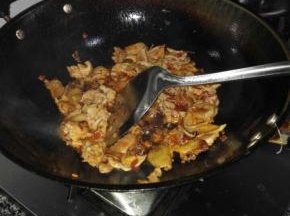 倒入姜粒和蒜片，腌好的瘦肉混炒，瘦肉变色后倒入青笋