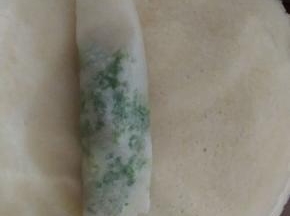 把馅放入春卷皮上，将其包裹起来