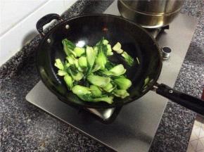 倒入上海青爆炒几下，放入适量的水加盖30秒