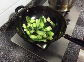 倒入上海青爆炒几下，放入适量的水加盖30秒