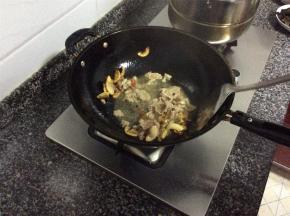 肥肉煸出油后，肉片呈金黄焦脆状，放入姜丝、蒜片和干辣椒，倒入瘦肉片翻炒