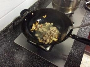 肥肉煸出油后，肉片呈金黄焦脆状，放入姜丝、蒜片和干辣椒，倒入瘦肉片翻炒