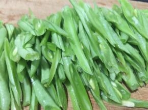 四季豆撕筋去头尾，斜切成丝