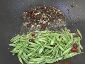 油锅烧热，倒入干辣椒、猪肉馅、芽菜爆炒，翻炒几下后加入四季豆
