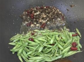 油锅烧热，倒入干辣椒、猪肉馅、芽菜爆炒，翻炒几下后加入四季豆