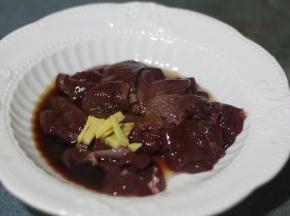 在熬粥的同时，将猪肝洗净切片，用盐、料酒、油、玉米淀粉和姜丝腌制片刻