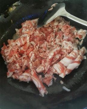 炒锅热油放入羊肉片，放入料酒去膻气