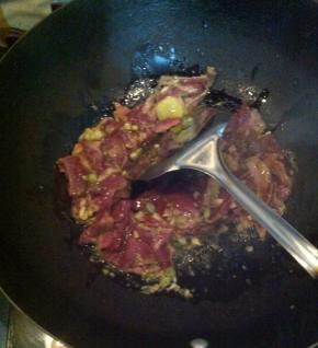 放入姜蒜爆香，将腌好的牛肉放入翻炒