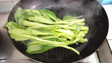 锅内加水，加少量的盐煮沸，放入菜心